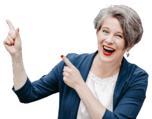 Katrin trägt eine weiße Bluse und einen dunkelblauen leichten Blazer. Ihre Hände zeigen nach links.